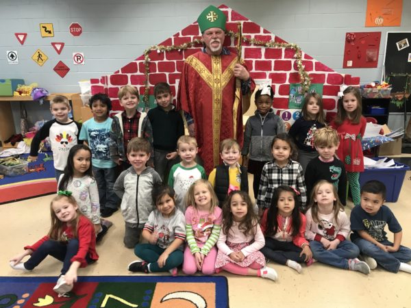 Children pose with a man dressed as St. Nicolas