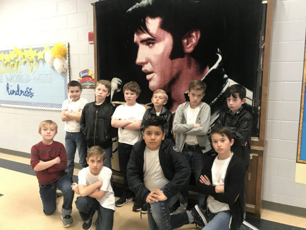 Children stand in front of an Elvis poster