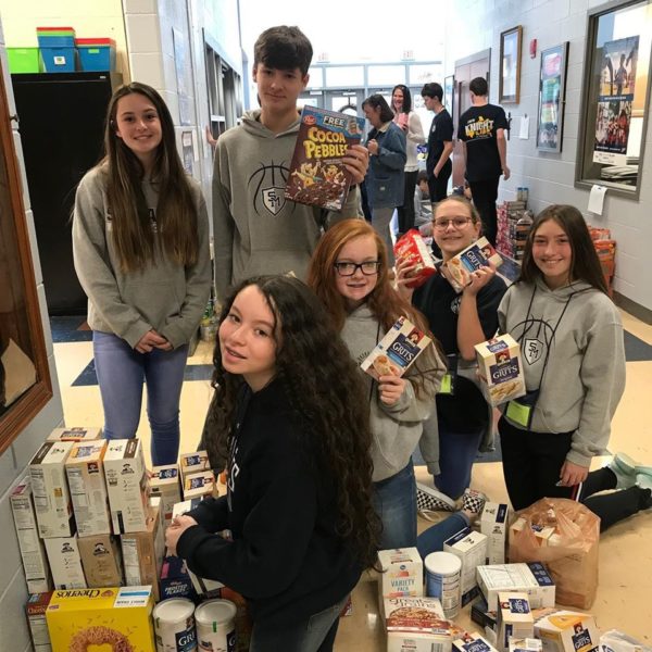 A group of students gathers food donations