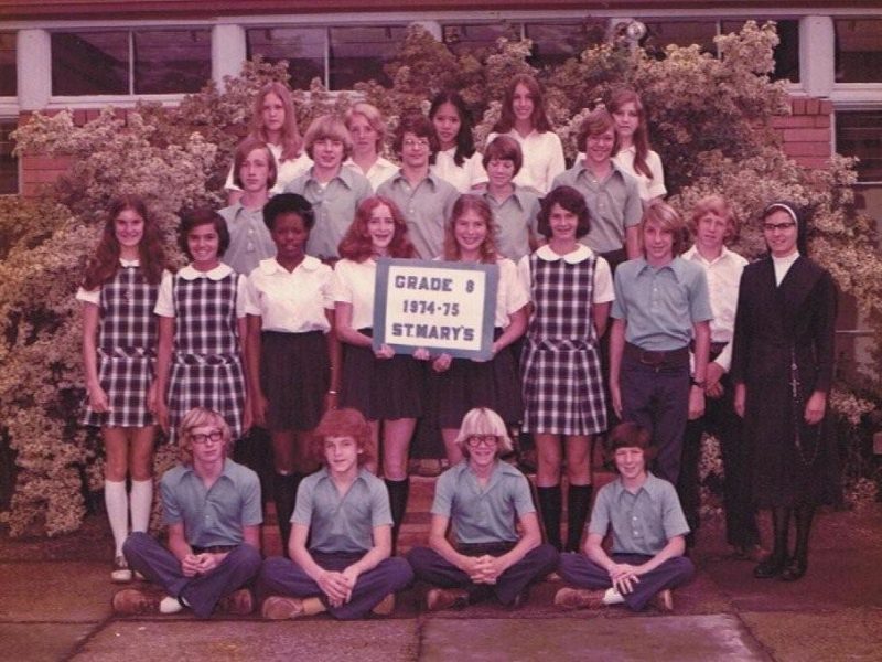 Students stand next to a sign that says Grade 8 1974-75